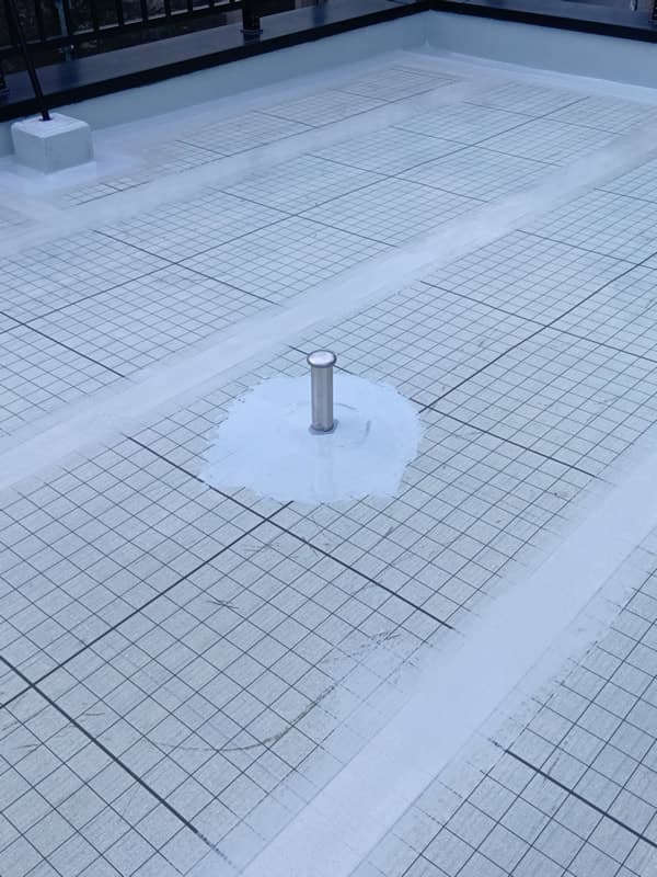 施工中屋上防水（通気緩衝工法）自着シート張付けと脱気筒の取付け